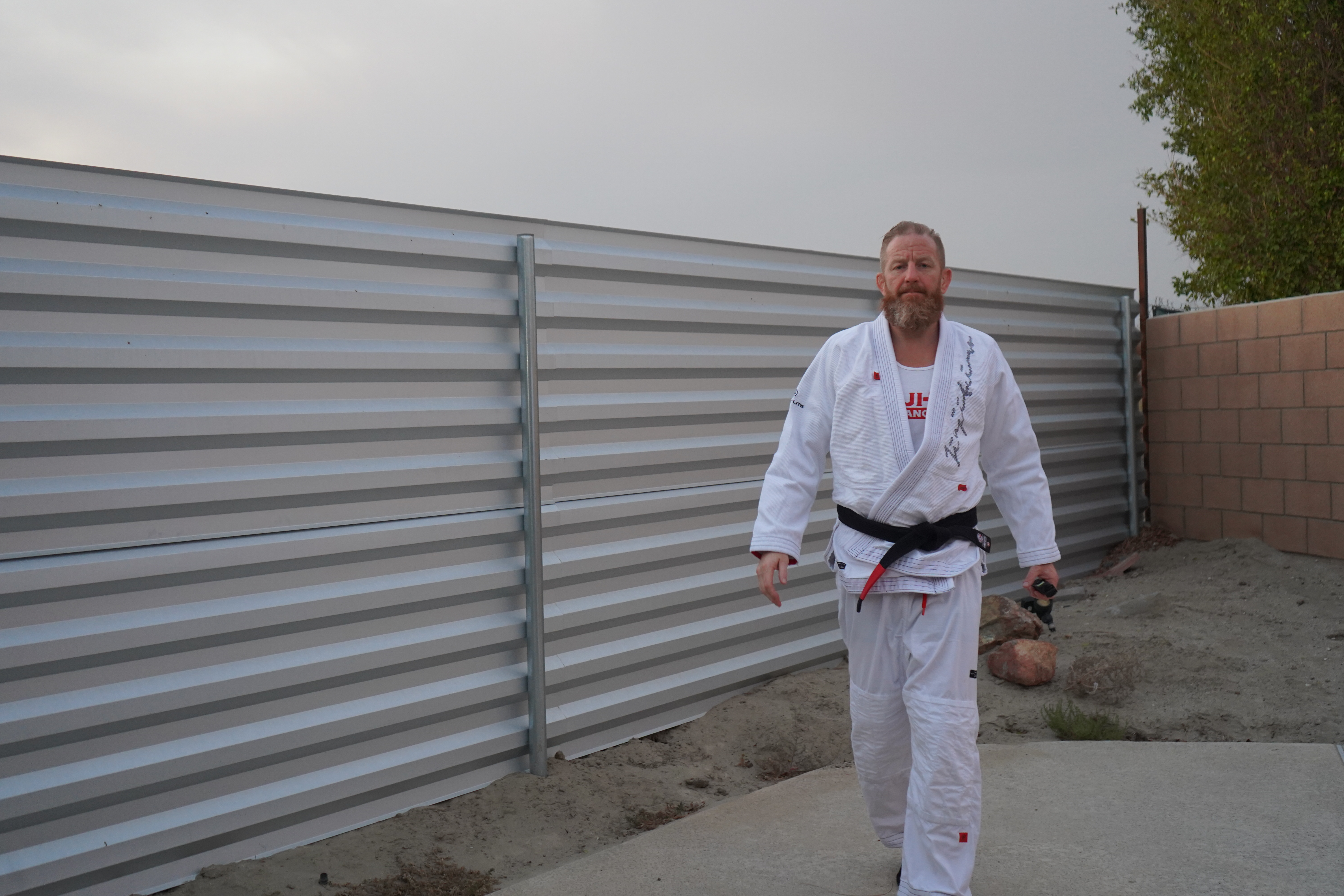 Chris Martin in white gi with black belt